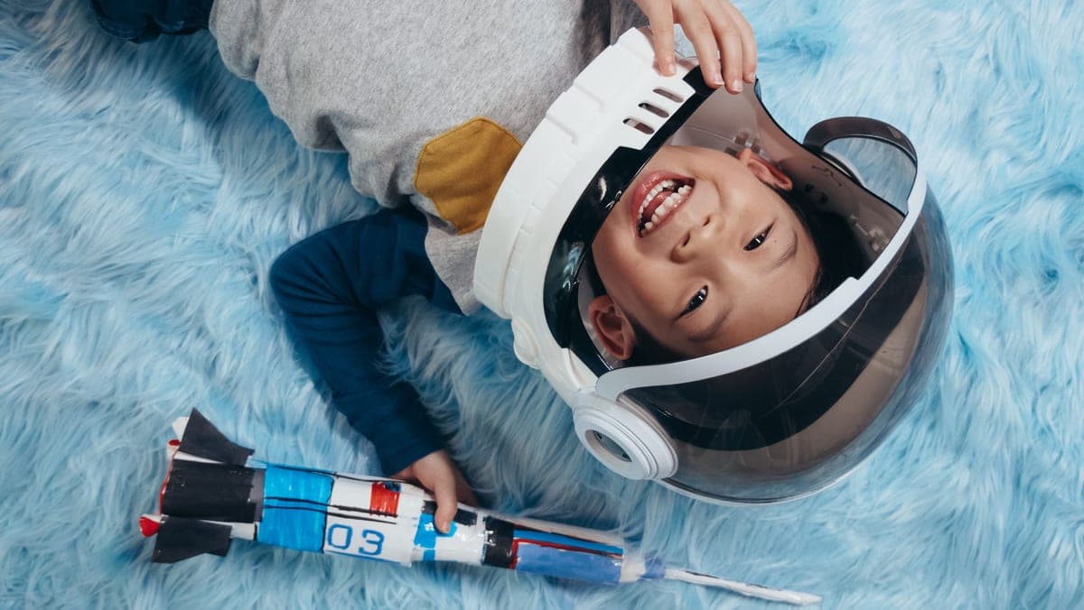 A child playing in a homemade astronaut costume