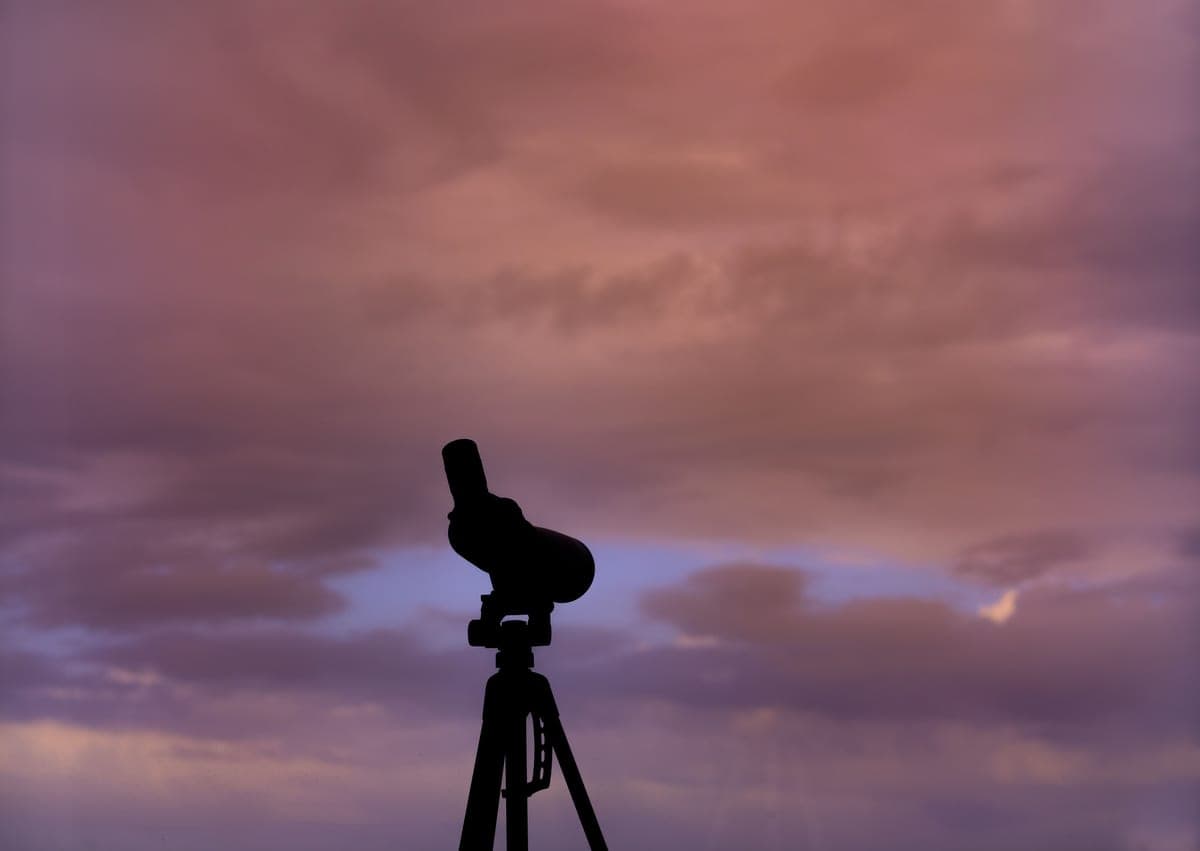 A small telescope standing on a tripod outdoors